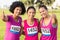 Three smiling runners supporting breast cancer marathon
