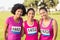 Three smiling runners supporting breast cancer marathon