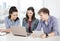 Three smiling students with laptop and tablet pc