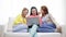 Three smiling teenage girls with laptop at home