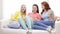 Three smiling teenage girls watching tv at home