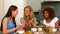 Three smiling young female friends reading text message