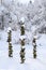 Three snow covered stacks of round rocks in a peaceful snowy zen garden