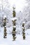 Three snow covered stacks of round rocks in a peaceful snowy zen garden