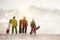 Three snowboarders stands against mountains
