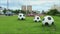 Three soccer balls by the road