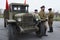 Three soviet soldiers standing near army lorry