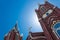 Three spires with white crosses against blue sky, Gothic Revival church