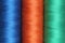 Three spools of polyester threads