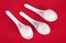 Three spoons with dumplings on the red background