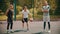 Three sportsmens standing on the basketball court outdoors and looking in the camera - one sportsman hitting the ball