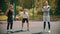 Three sportsmens standing on the basketball court outdoors and looking in the camera - one of them playing with a ball