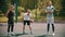 Three sportsmens standing on the basketball court outdoors - one sportsman doing keepy-uppies