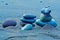 Three stacked balanced stones or pebbles on black volcanic sand