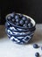 Three stacked ceramic bowls with ripe blueberries