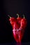 Three standing bound red pointed peppers in atmospheric light