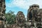 Three statues carved with face shapes on four sides on the roofs of the ruins of the Bayon temple in Ankgor Thom, Cambodia -