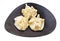 Three steamed Buuz on black plate isolated