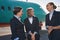 Three stewardesses laughing while standing on runway