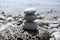 Three stone cairn tower on Madeira seacoast, poise stones, rock zen sculpture, light grey pebbles, blue ocean background