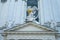 Three stone statues with gold shield and sword on the roof of church in Vienna