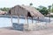 Three straw kiosks on the beach with blue sky and sand