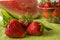 Three strawberries in Huelva on a green tablecloth.