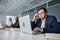 Three stressed young multiracial business people in businesswear working at desk on laptops in office