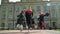 Three students in black and red mantles celebrating their graduation in front of university building. Graduation, new