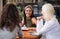 Three students reading books in cafe and talking