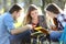 Three students studying outdoors on the grass