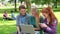 Three students using laptop together and laughing
