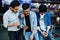 Three stylish asian mans wear on jeans looking at mobile phones and drink soda against table on club