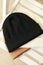 Three stylish beanies on wooden chair, top view