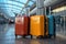 Three stylish colored suitcases standing in an empty airport