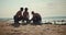 Three surfer guys adjusting their surfboards on the sandy seashore before swimming. car Surfers repair their surfboards