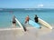 Three surfers enter the water in Honolulu