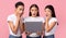 Three Surprised Girls Looking At Laptop Browsing Internet, Studio Shot