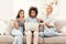 Three surprised women using laptop at home