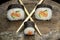 Three sushi rolls on a metal plate, with two chopsticks