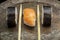 Three sushi rolls on a metal plate, with two chopsticks