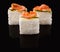 Three sushi in a row at black glass background