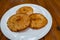 Three sweet arepas on a plate on a wooden table. Colombian cuisine