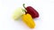 Three sweet peppers - white, yellow and red in water drops. Rotating on the turntable. Isolated on the white background