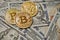 Three symbolic coins of bitcoin on banknotes of one hundred dollars. Exchange bitcoin cash for a dollar.