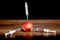 Three syringes are inserted into the apple with rot traces. Adoption of drugs. The problem of drug addiction. Intensive therapy_