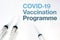 Three syringes isolated on a white background and the text of the covid-19 vaccination programme