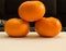 Three Tangerines Podium On Black Background