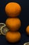 Three tangerines are stacked on top of each other on a black background.