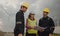 Three technician engineer in uniform with standing and checking wind turbine power farm power generator Station. Clean energy and